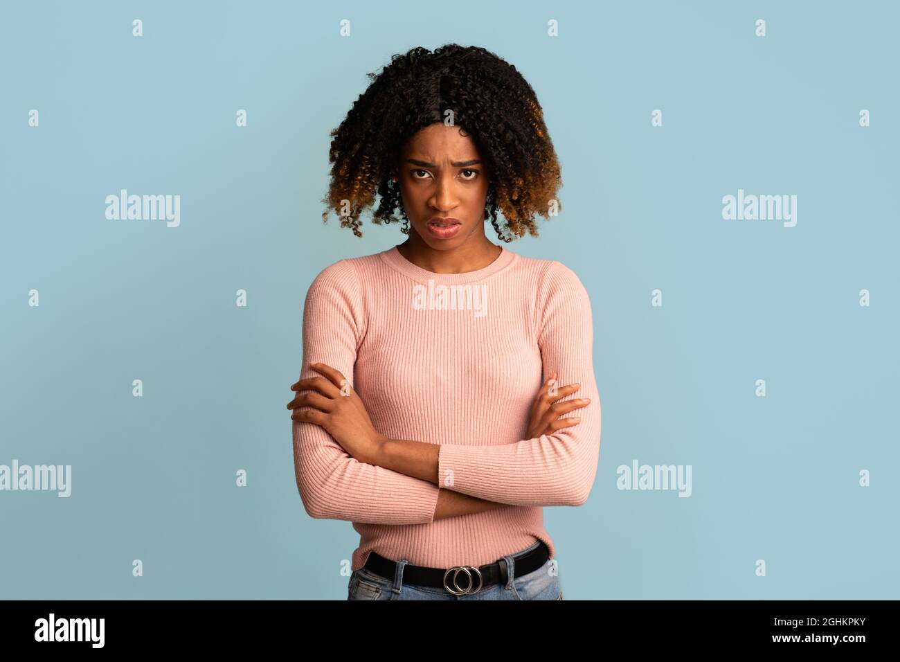 Ritratto di giovane donna afroamericana offesa in piedi con le braccia piegate Foto Stock
