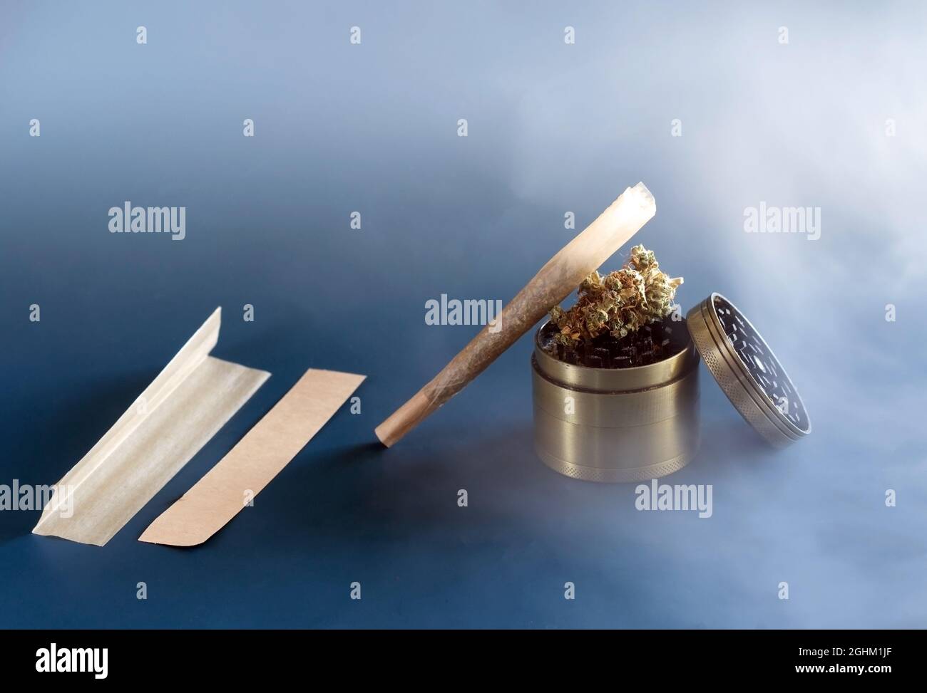 Cannabis indica giunti, germogli, e macinacaffè su un blu background.devices per torcere la sigaretta fatta in casa Foto Stock