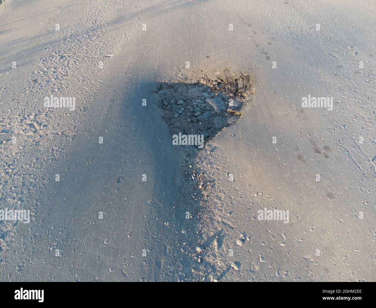 Buca sull'asfalto. Pothole sul fondo stradale Foto Stock