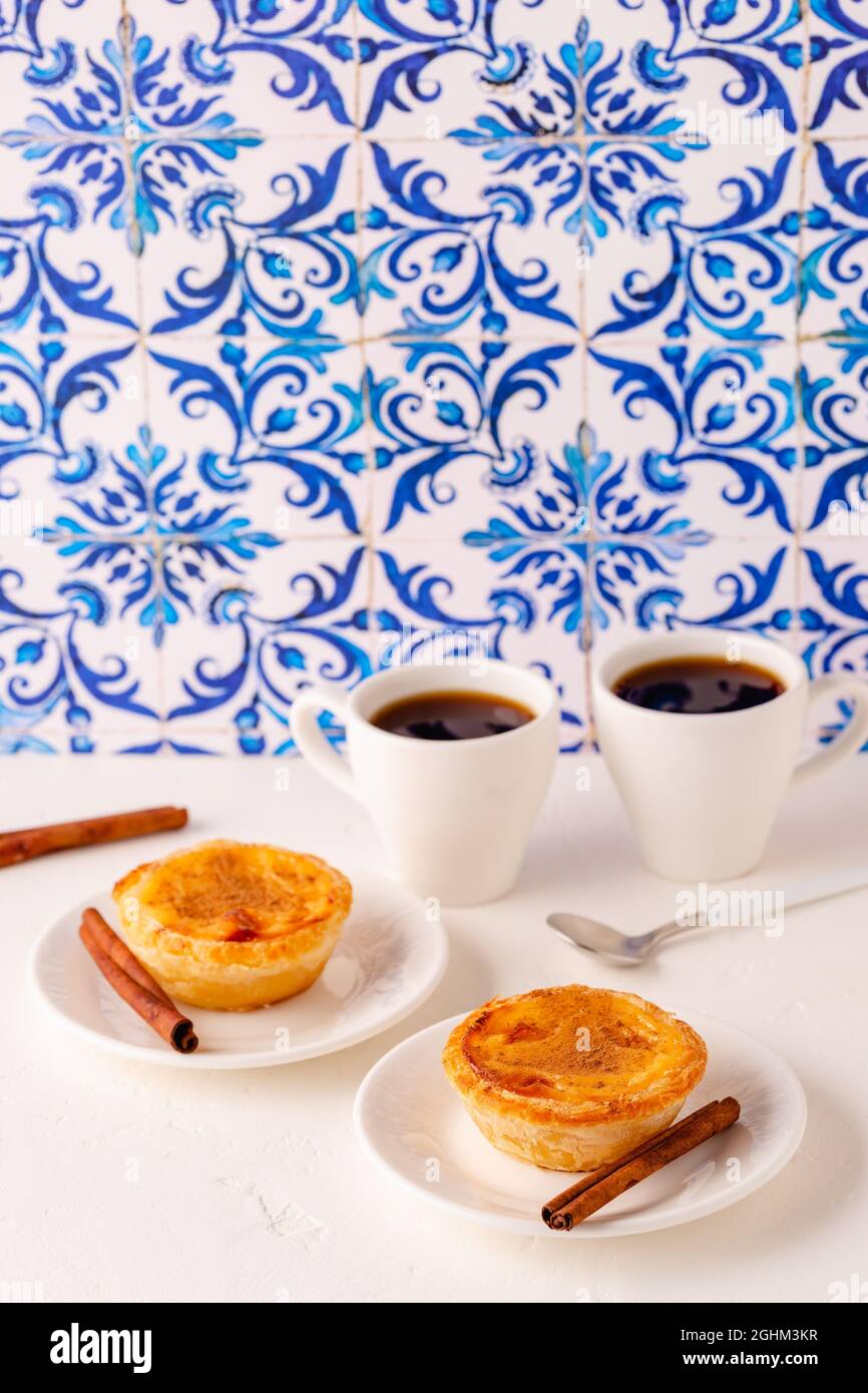 Freccette d'uovo, dessert tradizionale portoghese, pastello de nata/pastello de belem. Sfondo piastrellato Azulejo. Foto Stock