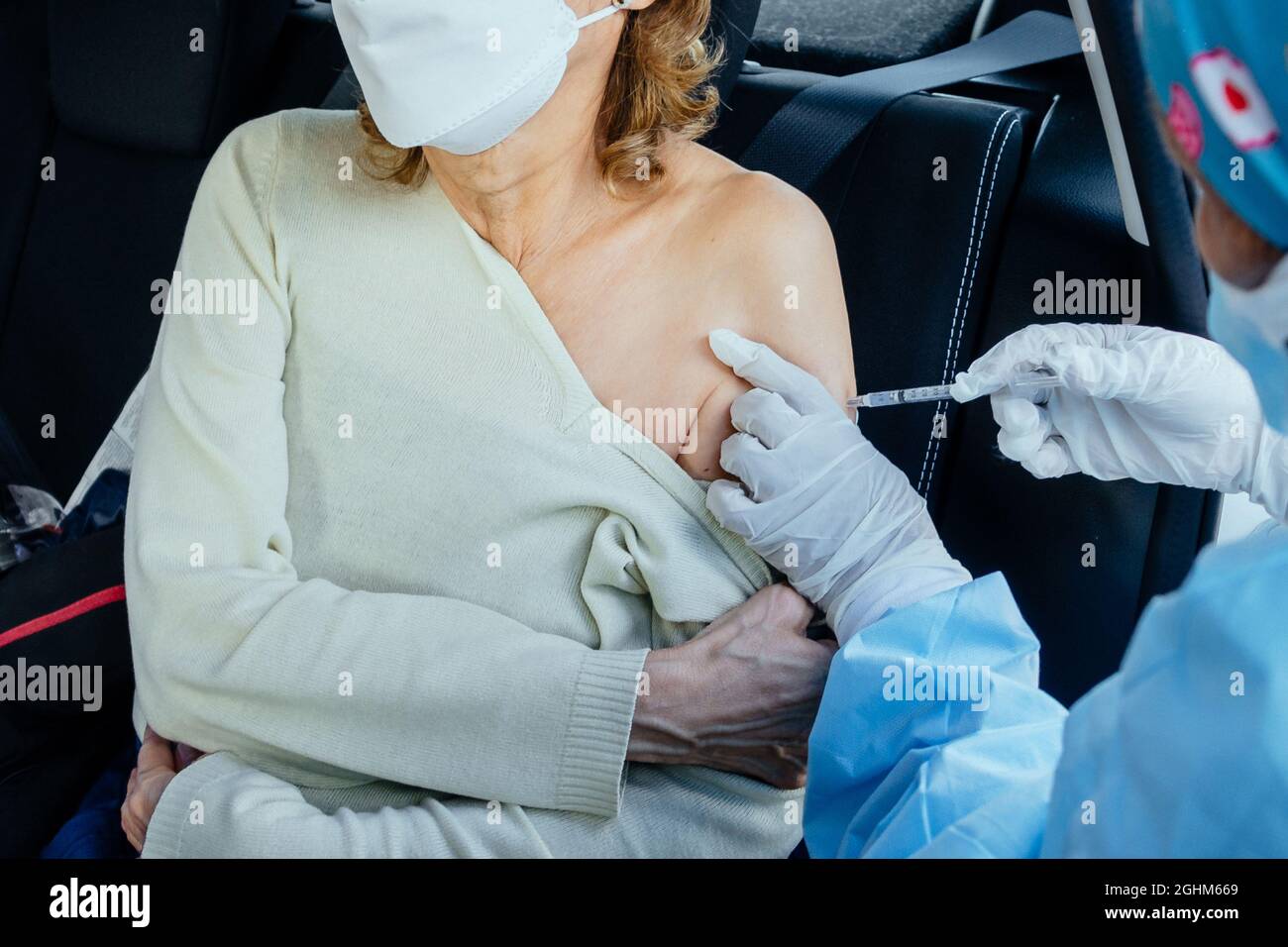 Una donna anziana che riceve l'iniezione del vaccino contro il coronavirus da parte di un infermiere per ricevere gli anticorpi, immunizzare la popolazione effetti indesiderati, persone a rischio, anticorpi, nuovo normale, covid-19 Foto Stock