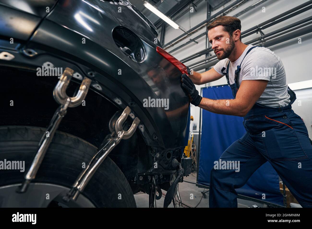 L'uomo spinge le luci di posizione posteriori dell'auto da dietro Foto Stock