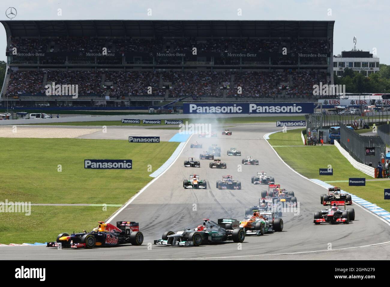 Sebastian Vettel (GER) Red Bull Racing RB8 e Michael Schumacher (GER) Mercedes AMG F1 W03 lottano per la seconda posizione al via della gara. 22.07.2012. Formula 1 World Championship, Rd 10, Gran Premio di Germania, Hockenheim, Germania, Giorno di gara Foto Stock