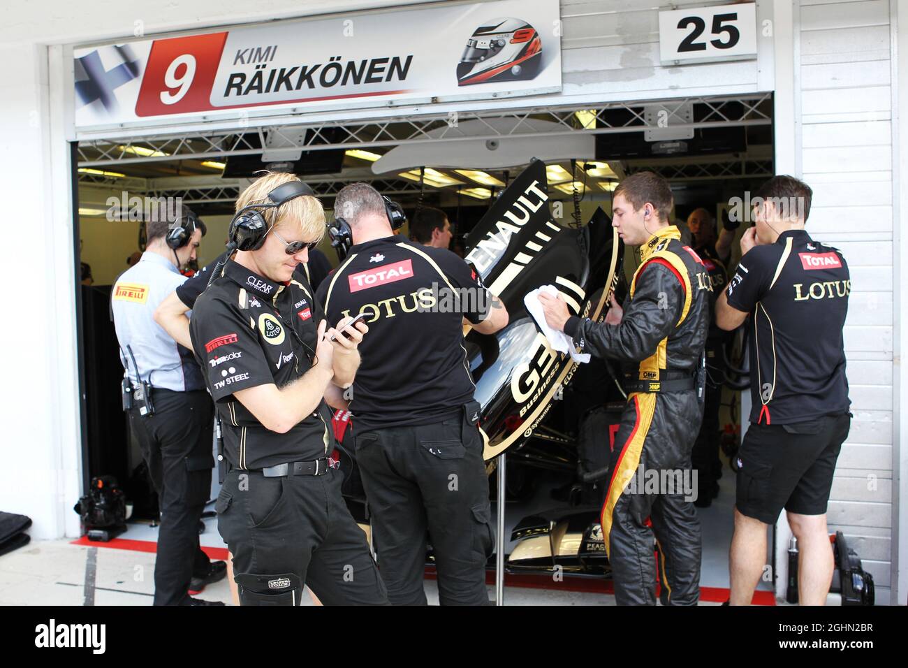 Andy Stobart (GBR) Lotus F1 Team Press Officer e il Lotus F1 Team formano uno scudo umano da Kimi Raikkonen (fin) Lotus F1 E20 nei box. 27.07.2012. Formula 1 World Championship, Rd 11, Gran Premio d'Ungheria, Budapest, Ungheria, Giorno della pratica Foto Stock