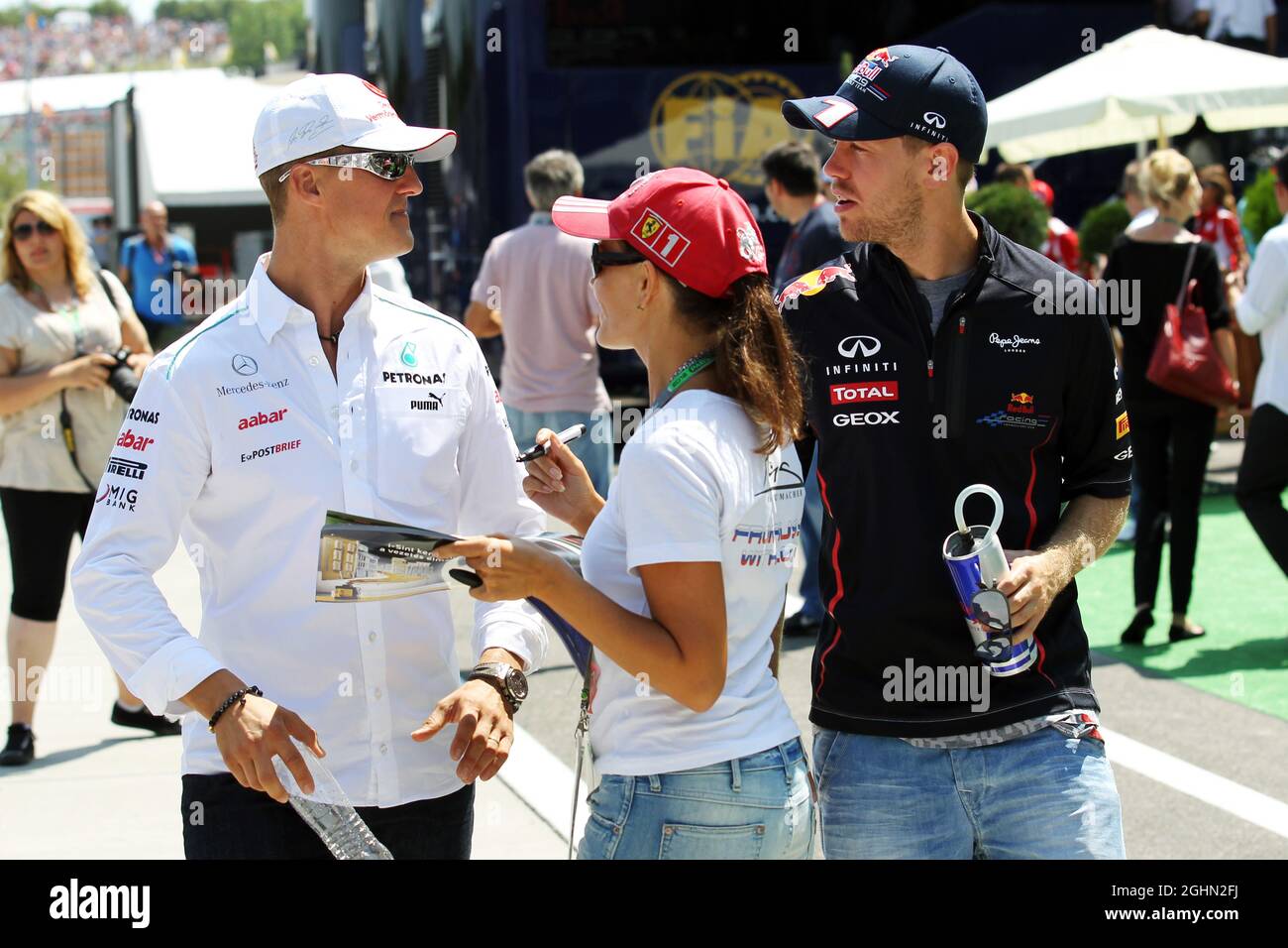 (Da L a R): Michael Schumacher (GER) Mercedes AMG F1 e Sebastian Vettel (GER) Red Bull Racing con un fan. 29.07.2012. Formula 1 World Championship, Rd 11, Gran Premio d'Ungheria, Budapest, Ungheria, Giorno di gara Foto Stock