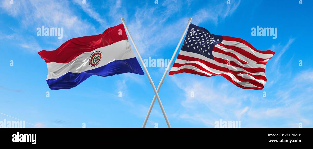 Bandiere degli Stati Uniti e del Paraguay che ondeggiano nel vento su flagpoli contro il cielo con le nuvole in giorno di sole. Simbolizzare la relazione, il dialogo tra due conti Foto Stock