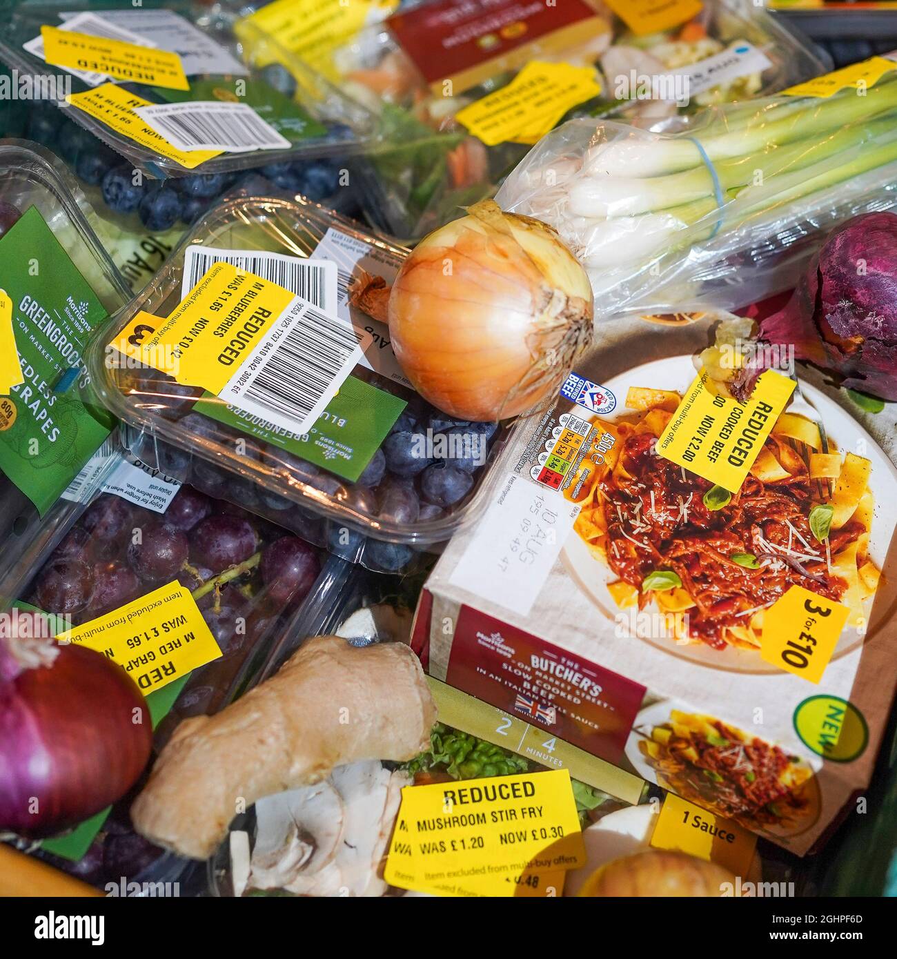 Selezione di prodotti alimentari per supermercati con adesivi gialli ridotti a causa della breve durata di conservazione, essendo obsoleti. Foto Stock