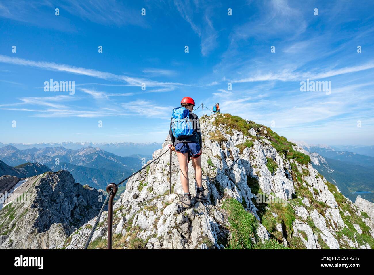 Alpinista su una cresta su una ferrata sicura via, Mittenwalder Hoehenweg, vista del panorama di montagna, Karwendel Mountains, Mittenwald, Baviera, Germania Foto Stock