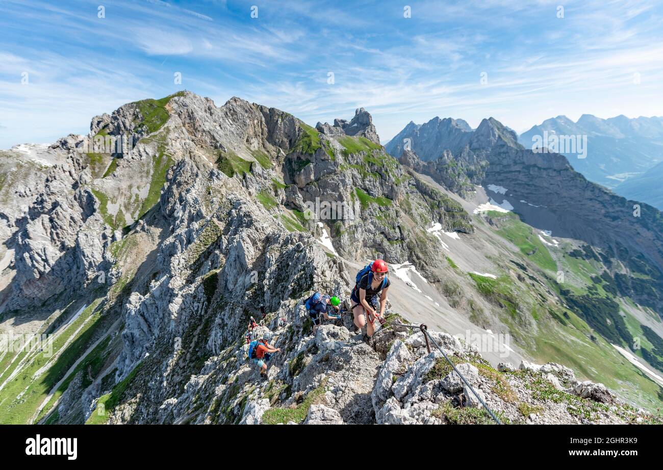 Alpinista su una cresta su un protetto via ferrata, Mittenwalder Hoehenweg, vista di cresta di montagna, Karwendel Mountains, Mittenwald, Baviera, Germania Foto Stock