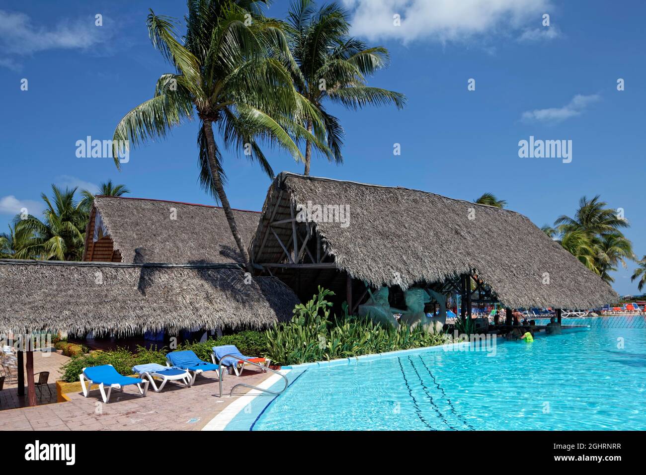 Piscina, pool bar con tetto di foglie di palma, lettini, palme da cocco (Cocos nusifera) Hotel Brisas, Playa St. Lucia, Camagueey Provincia, Caraibi, Cuba Foto Stock