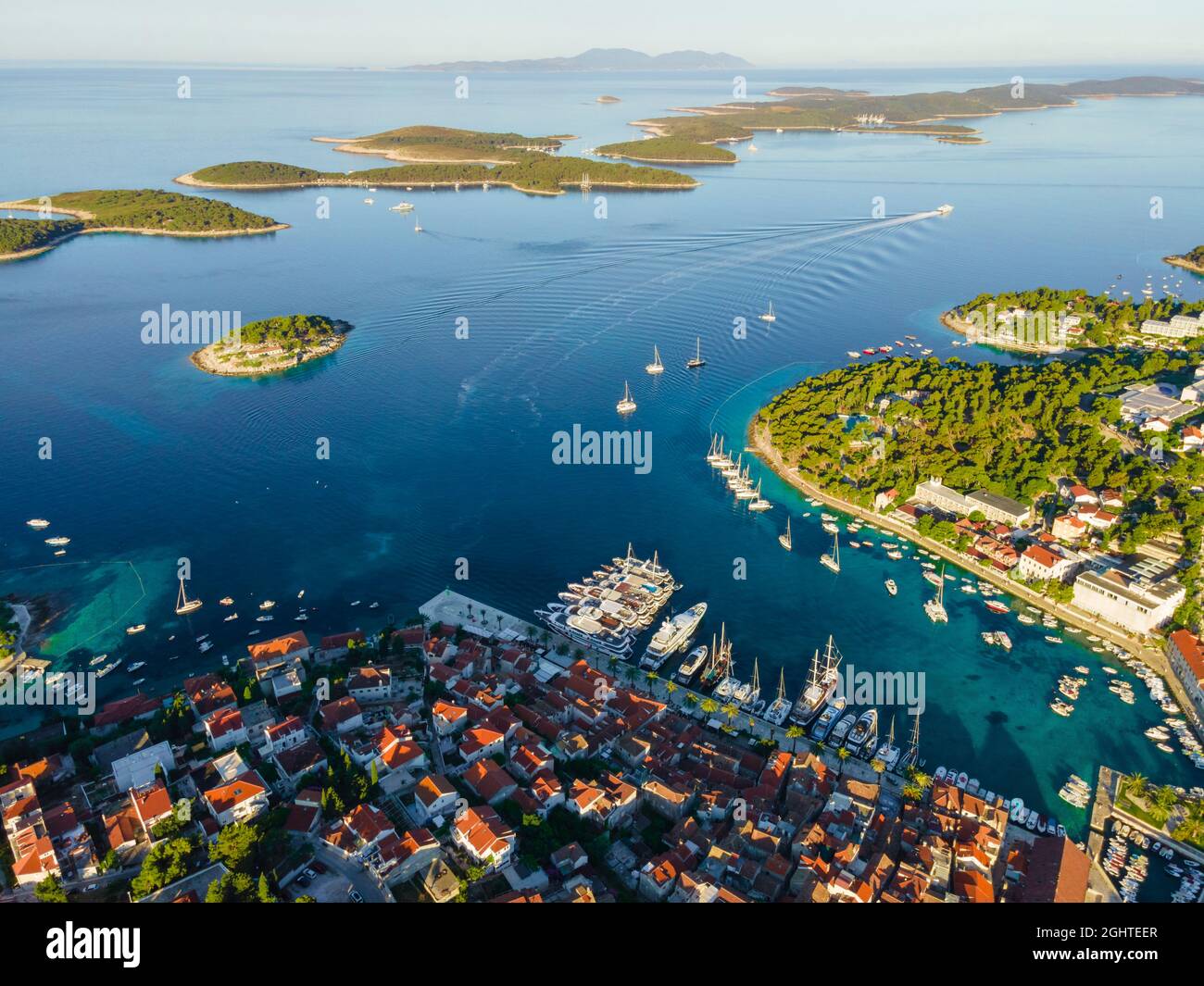 Vista aerea della città vecchia di Hvar con baia d'acqua turchese con yacht e isole in Croazia e mare Adriatico fatto con drone. Vacanze estive Foto Stock