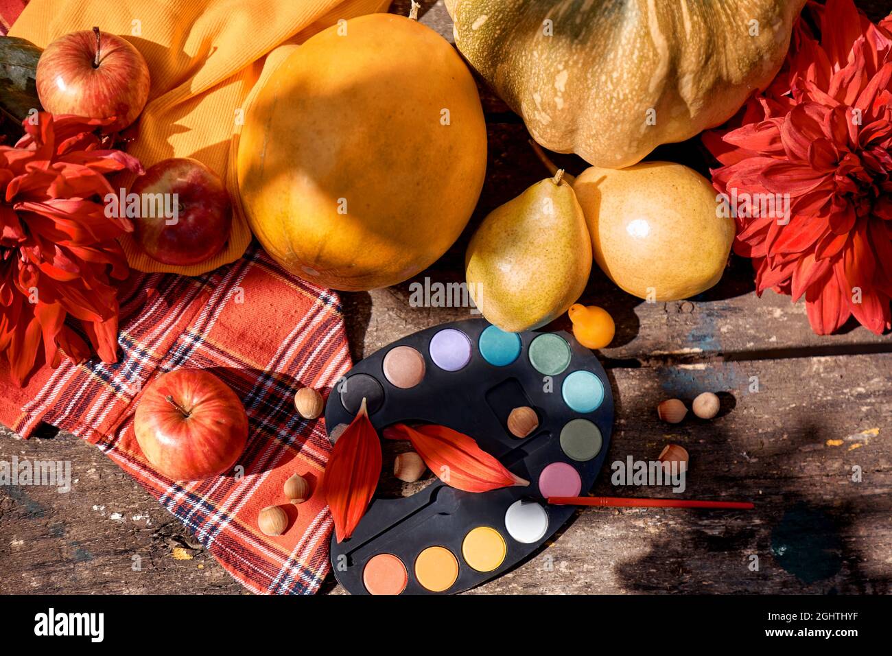 Piatto autunnale: Frutta gialla, verdure e vernici brillanti con pennello, zucca, pere, mela e melone. Autunno ancora vita con georgine rosso, più mugnito Foto Stock