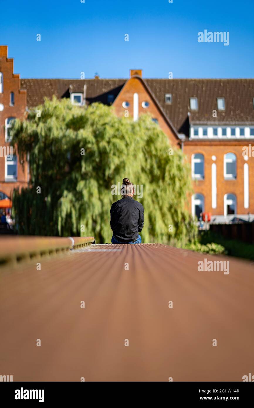 Uomo seduto sul bordo di un ormeggio Foto Stock