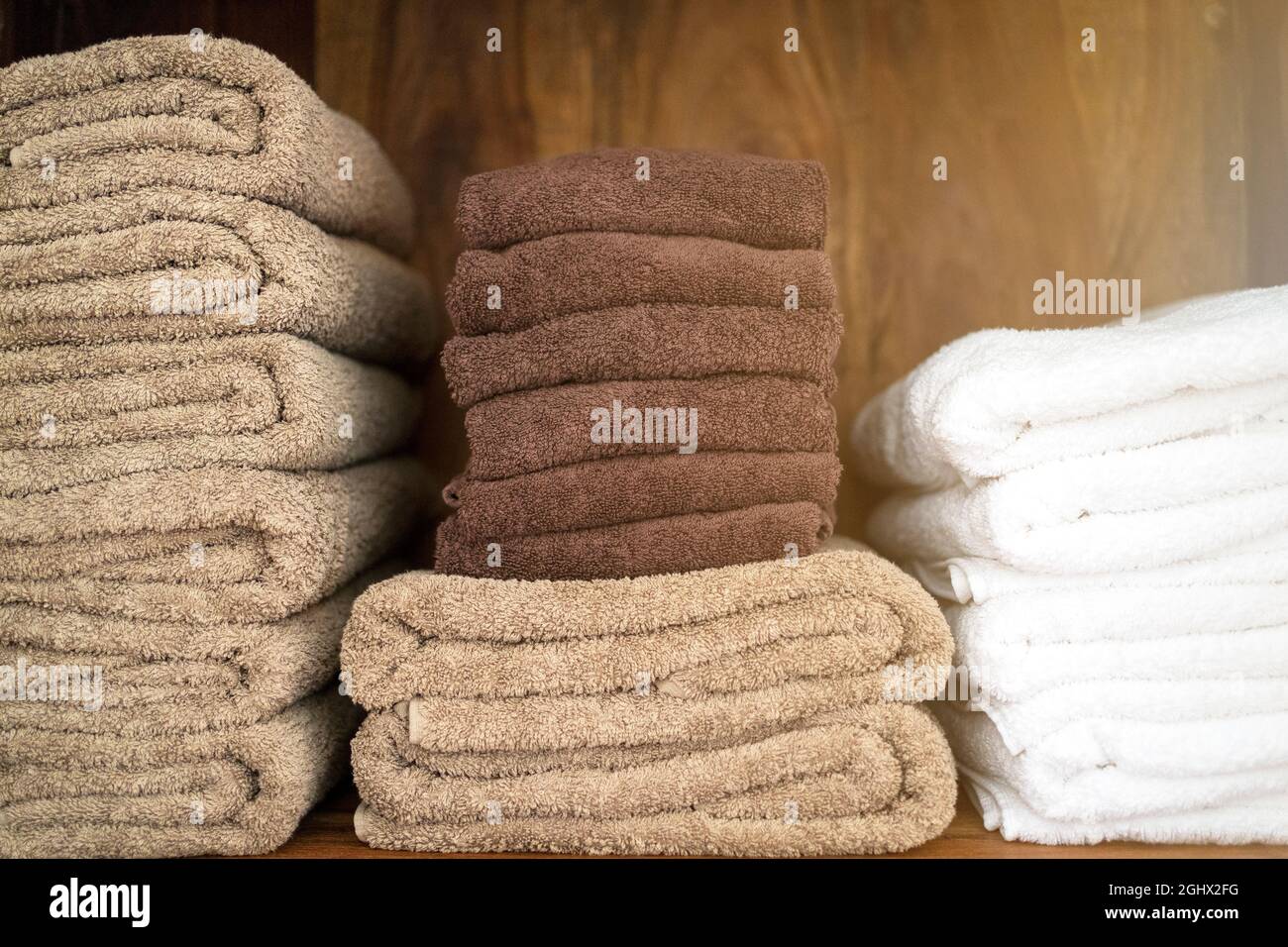 Pile di asciugamani, freschi e lavati. Spa massaggio benessere da hotel o casa all'interno di un armadio. Foto Stock