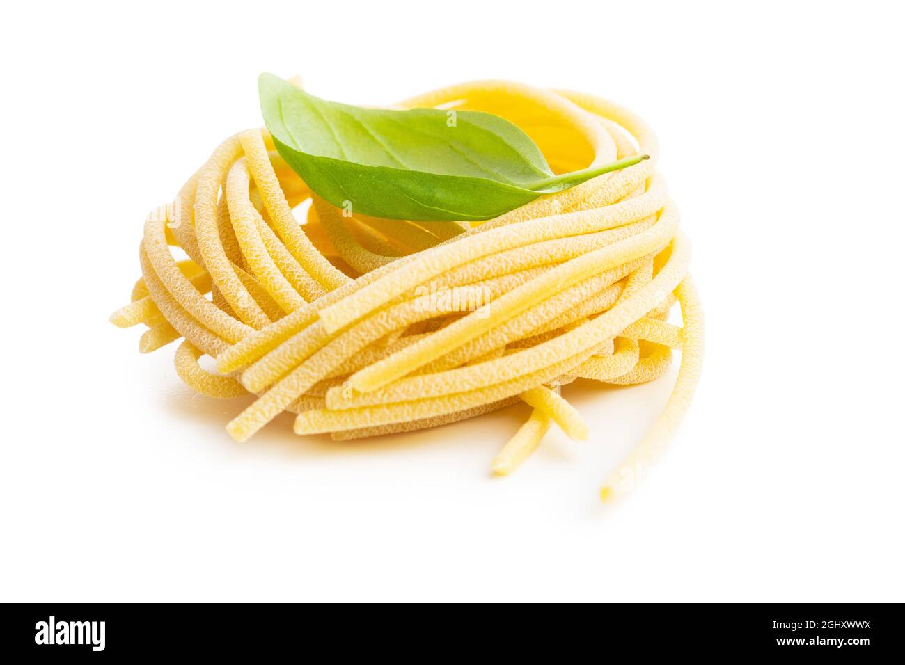 Nido di pasta italiana. Gli spaghetti non cotti nido isolato su sfondo bianco. Foto Stock
