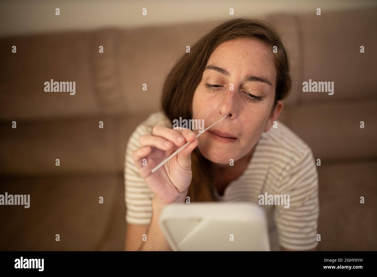 La donna esegue un autotest Covid-19 a casa Foto Stock