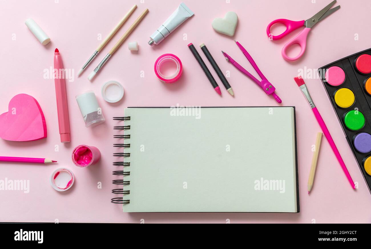 Concetto creativy dei bambini di ritorno alla scuola. Forniture scolastiche e notebook vuoto su sfondo rosa, spazio per testo, vista dall'alto Foto Stock