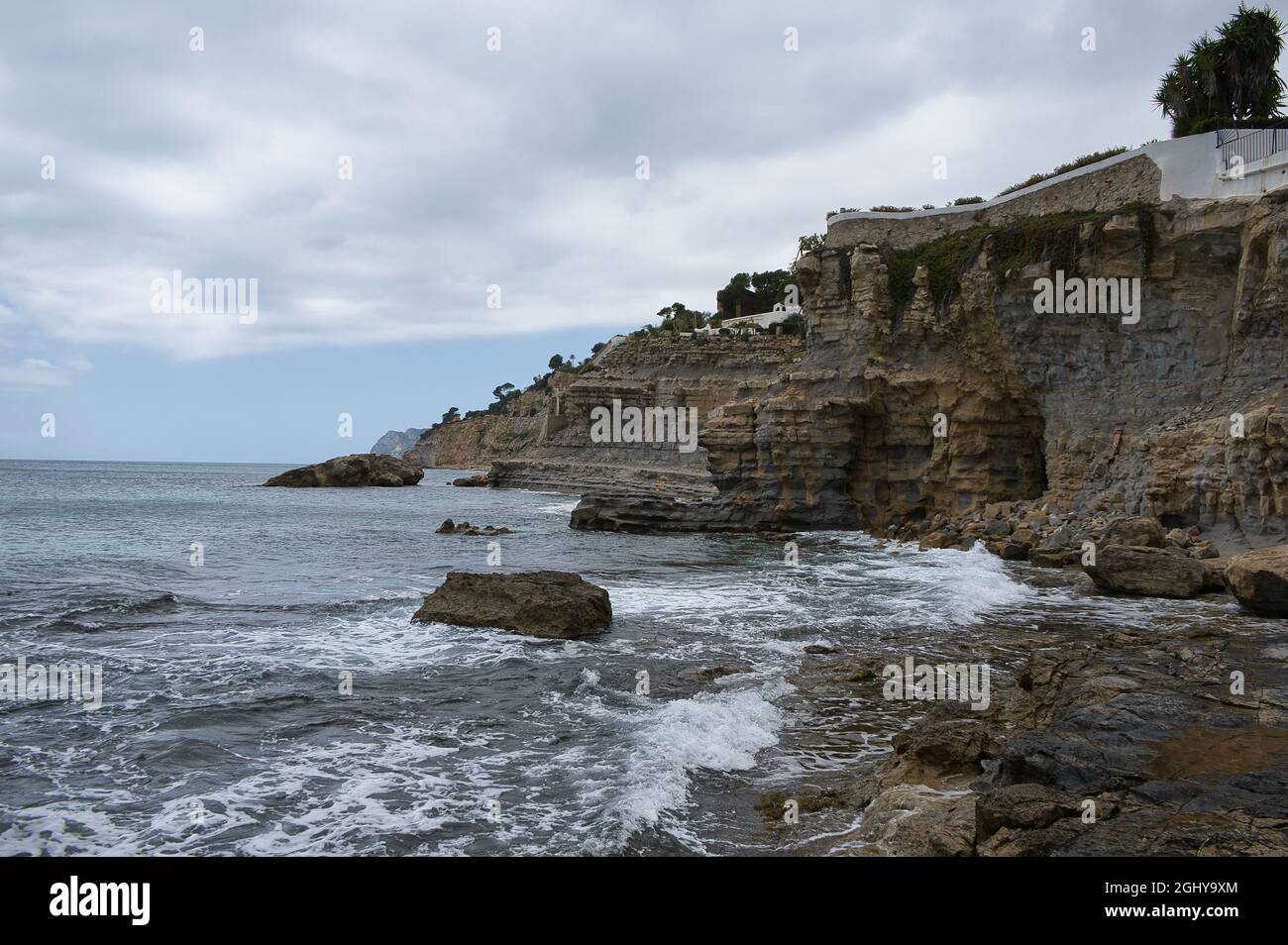 spiaggia con rocce sulla costa della città di Morarira in provincia di Alicante, Valencian comunità, Spagna. Vista Foto Stock