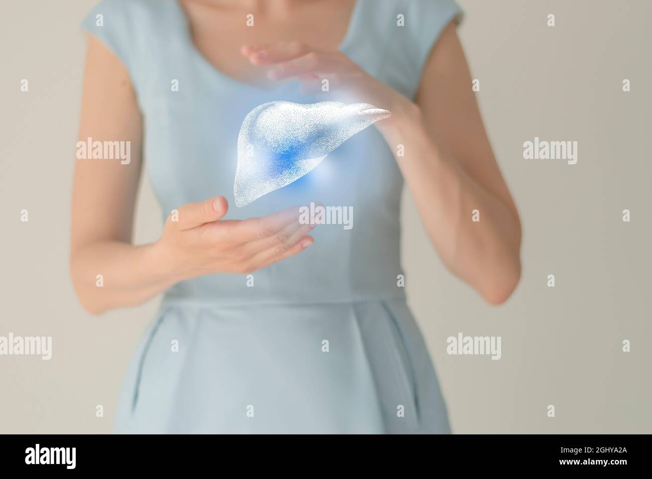 Paziente femminile irriconoscibile in abiti blu, evidenziato fegato di mano nelle mani. Concetto di problemi del sistema digestivo umano. Foto Stock