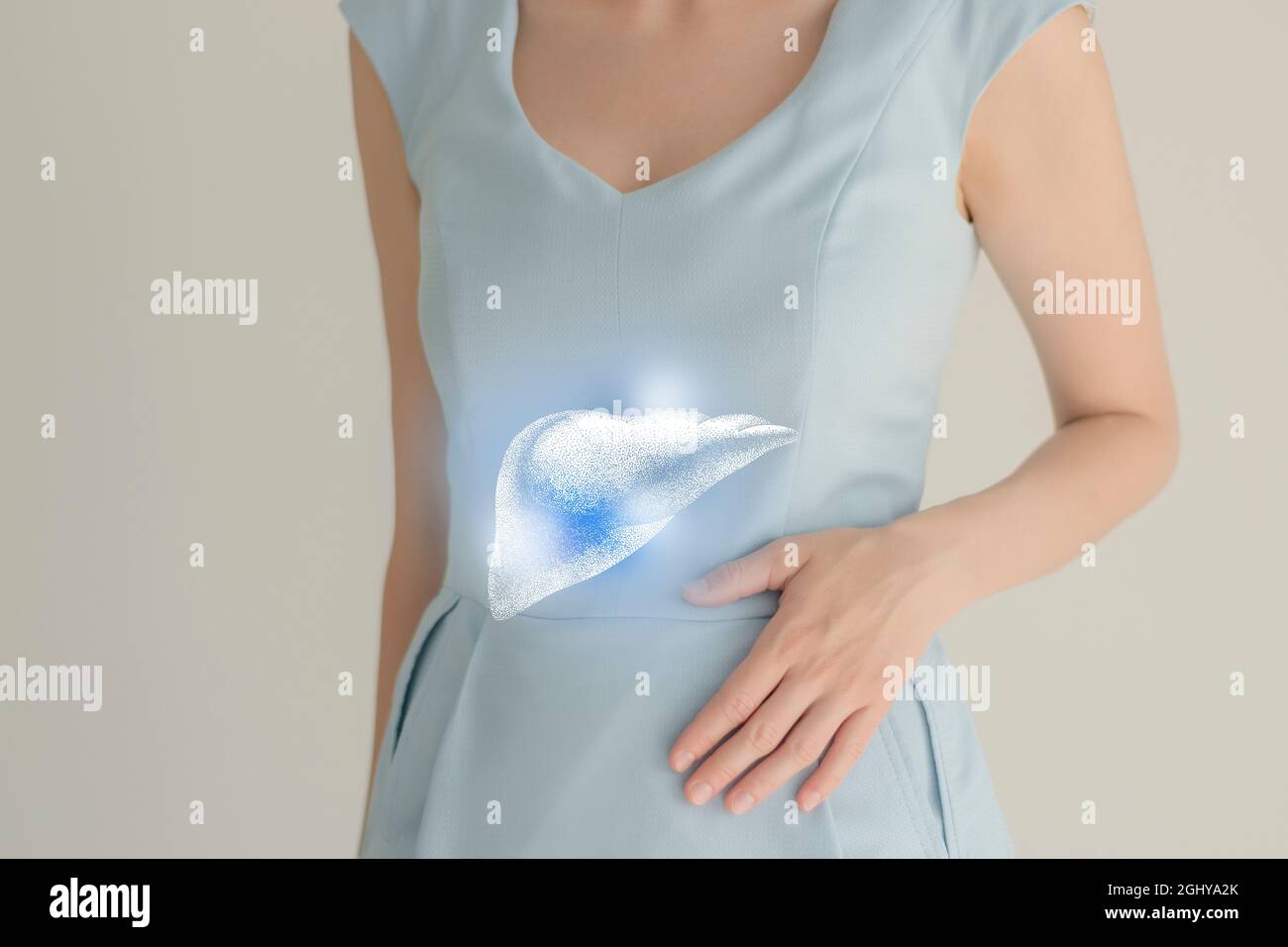 Paziente femminile irriconoscibile in abiti blu, evidenziato fegato di mano nelle mani. Concetto di problemi del sistema digestivo umano. Foto Stock