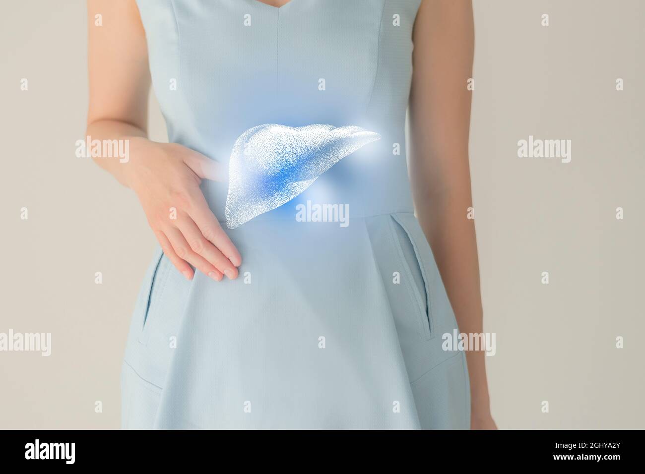 Paziente femminile irriconoscibile in abiti blu, evidenziato fegato di mano nelle mani. Concetto di problemi del sistema digestivo umano. Foto Stock