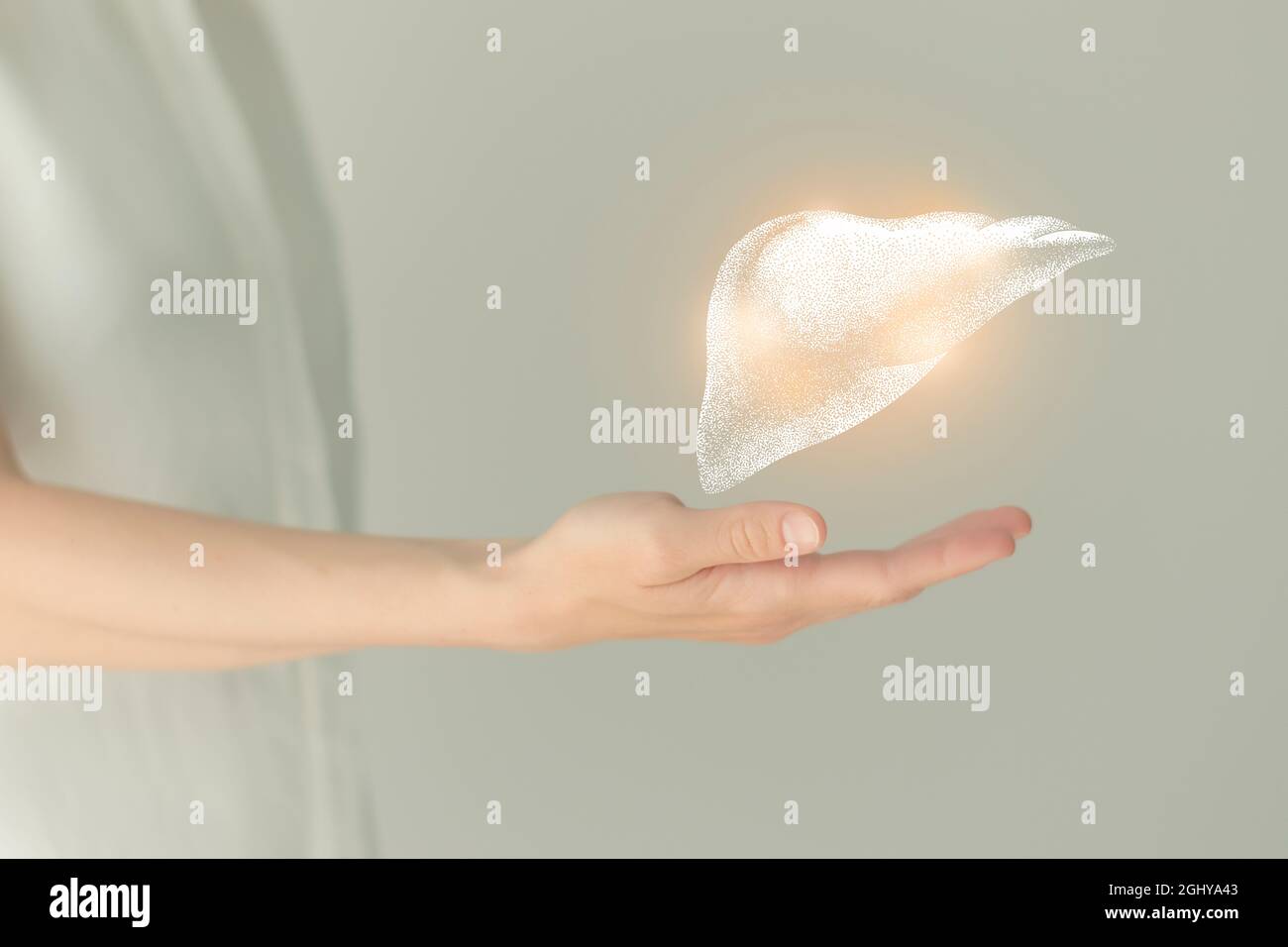 Paziente femminile irriconoscibile in abiti bianchi, evidenziato fegato di mano nelle mani. Concetto di problemi del sistema digestivo umano. Foto Stock