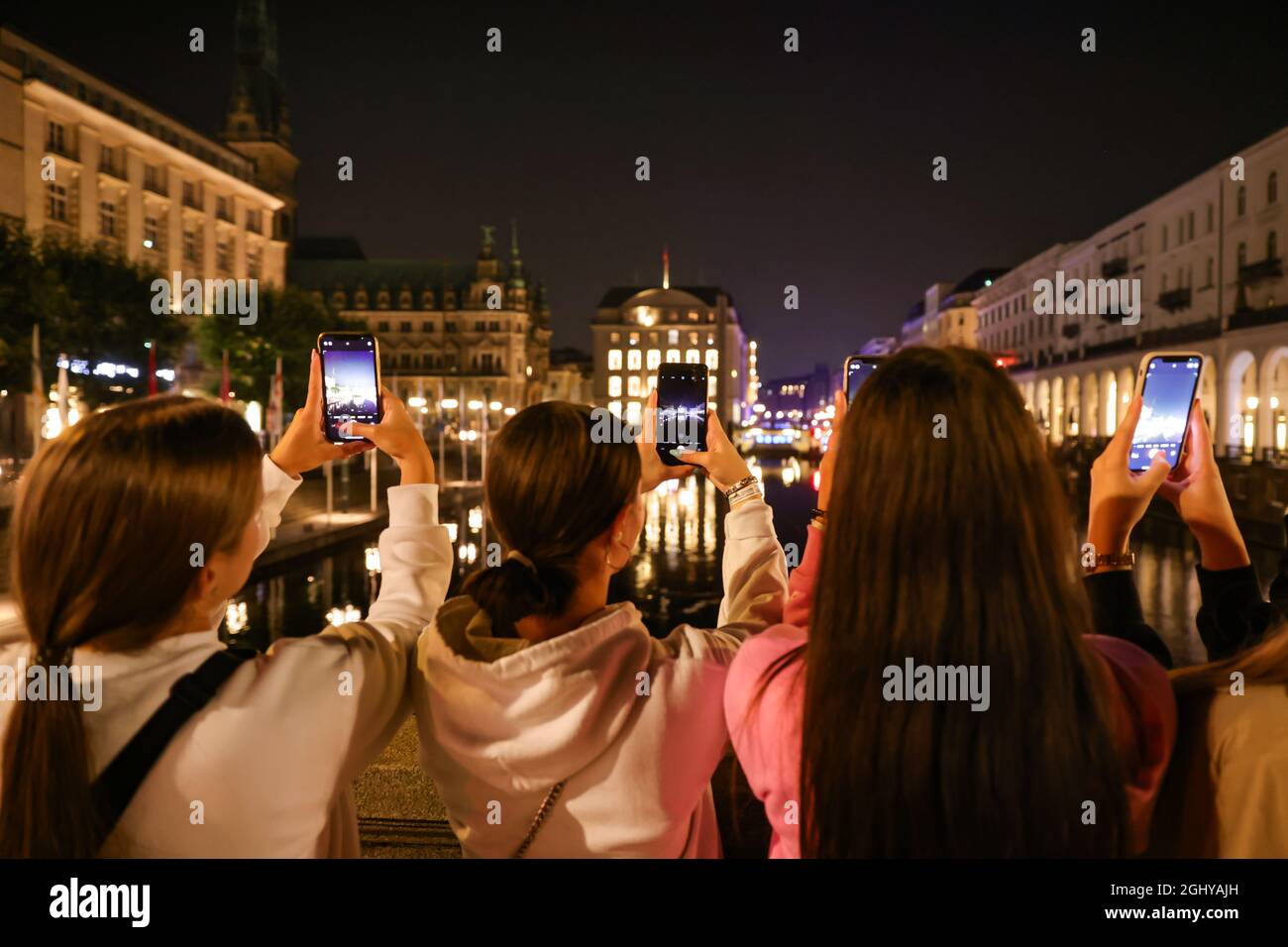 Amburgo, Germania. 07 settembre 2021. Le giovani donne fotografano il Municipio di Amburgo non illuminato. Amburgo partecipa alla "Notte della Terra" per attirare l'attenzione sul persistente inquinamento luminoso di notte. Nella notte della Terra, l'illuminazione degli edifici viene disattivata come segno visibile per una luce meno artificiale. Credit: Ulrich Perrey/dpa/Alamy Live News Foto Stock