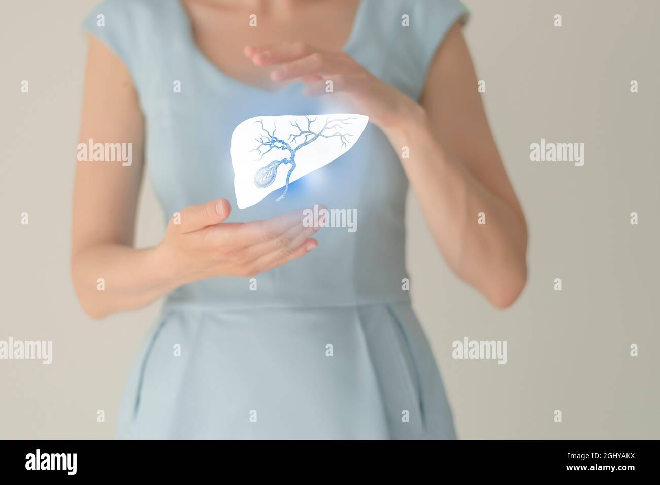 Paziente femminile irriconoscibile in abiti blu, evidenziata la cistifellea di corbone nelle mani. Concetto di problemi del sistema digestivo umano. Foto Stock