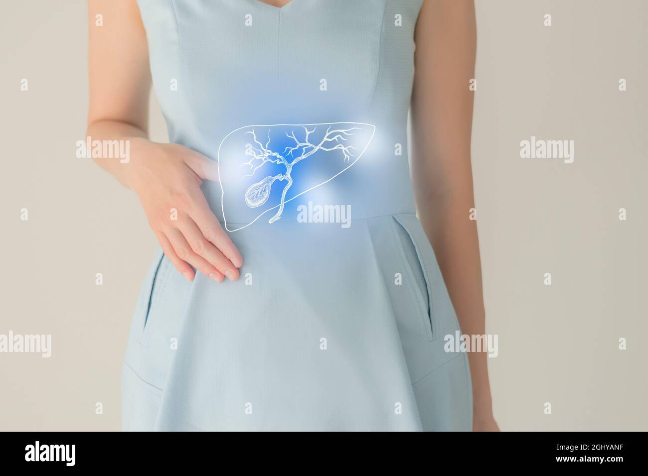 Paziente femminile irriconoscibile in abiti blu, evidenziata la cistifellea di corbone nelle mani. Concetto di problemi del sistema digestivo umano. Foto Stock