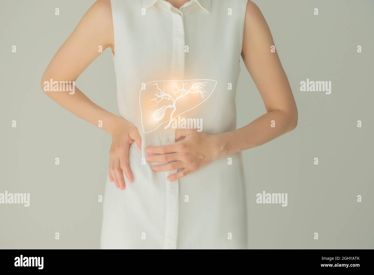Paziente femminile irriconoscibile in abiti bianchi, evidenziata la cistifellea di corbone nelle mani. Concetto di problemi del sistema digestivo umano. Foto Stock