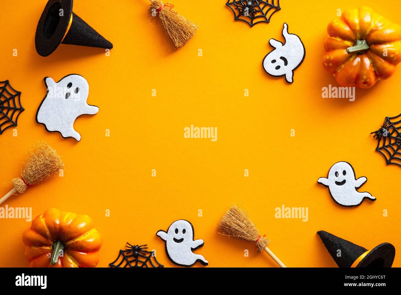 Felice Halloween concetto di vacanza. Decorazioni di Halloween, zucche, fantasmi, cappelli di streghe, scopa su sfondo arancione. Biglietto d'auguri per Halloween party MOC Foto Stock