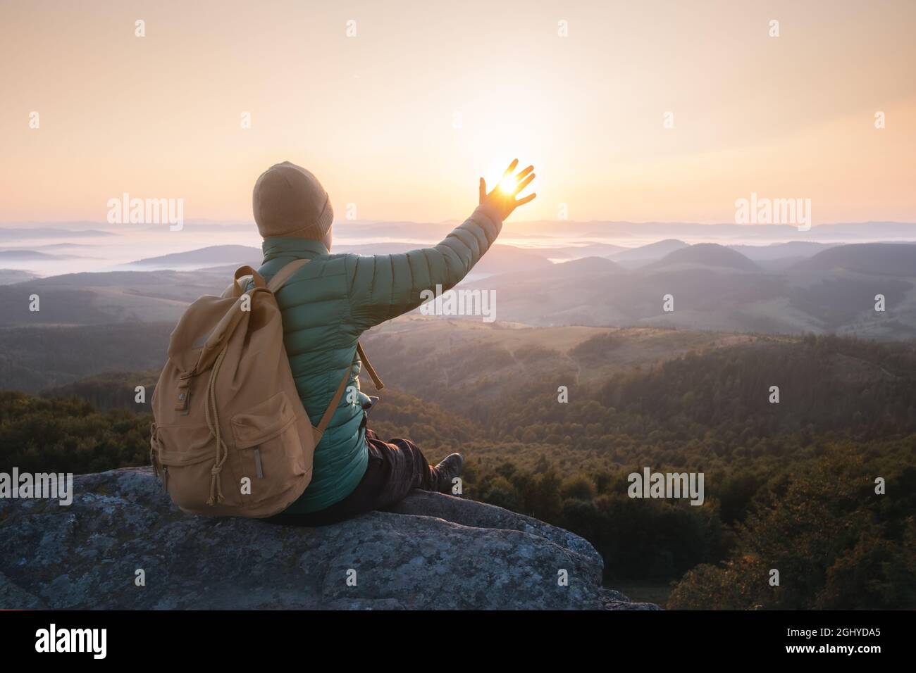 Solo turista sul bordo della scogliera sullo sfondo di un incredibile paesaggio di montagna prendere il sole. Fotografia di paesaggio Foto Stock