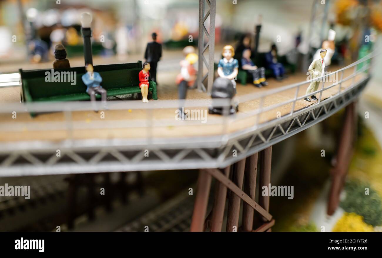 primo piano di piste, città, edifici e persone sul treno giocattolo set Foto Stock