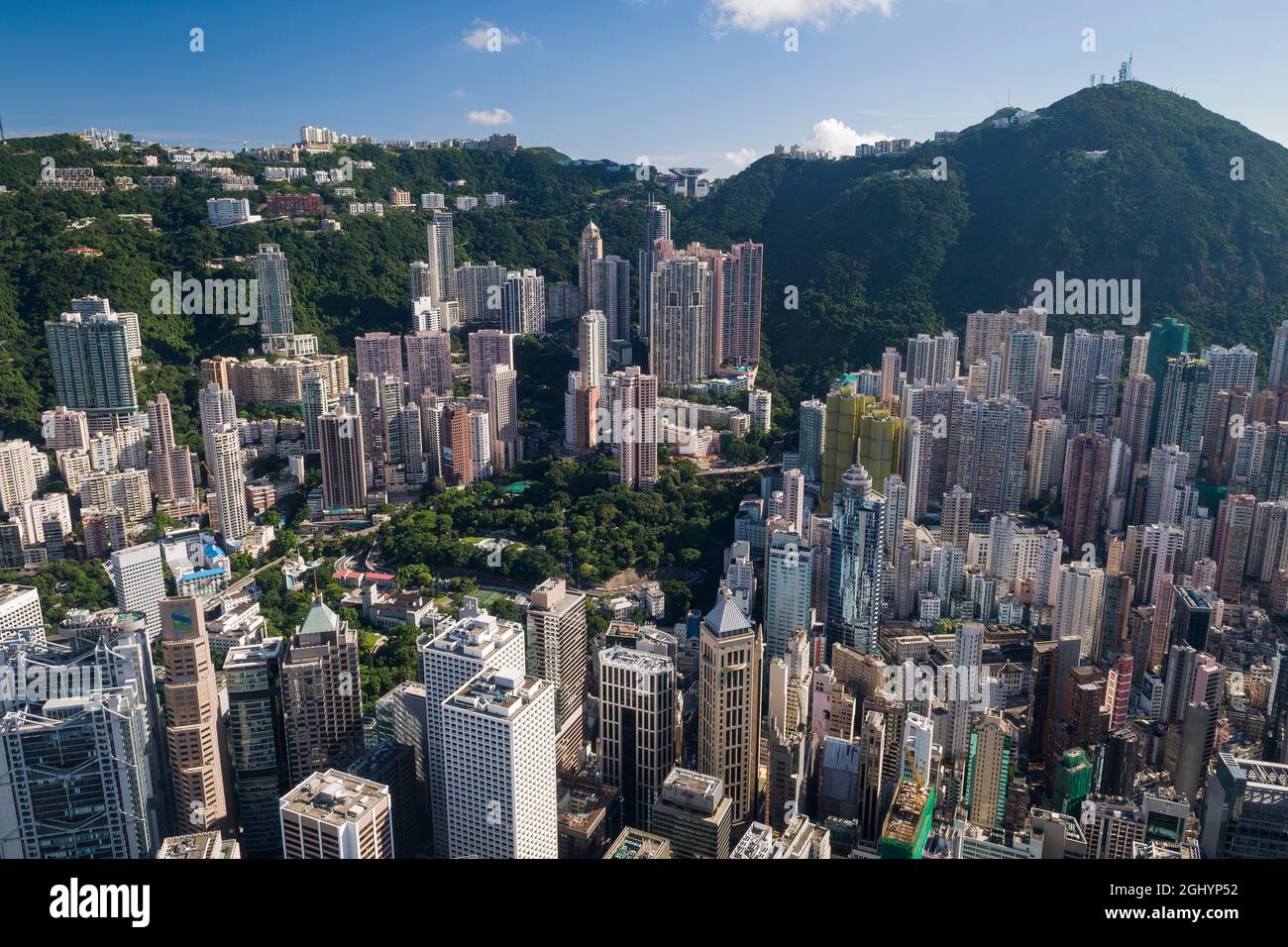 Gli alti blocchi di appartamenti residenziali di Mid-level e case di lusso sul Peak sopra gli edifici commerciali di Central, Hong Kong Island Foto Stock