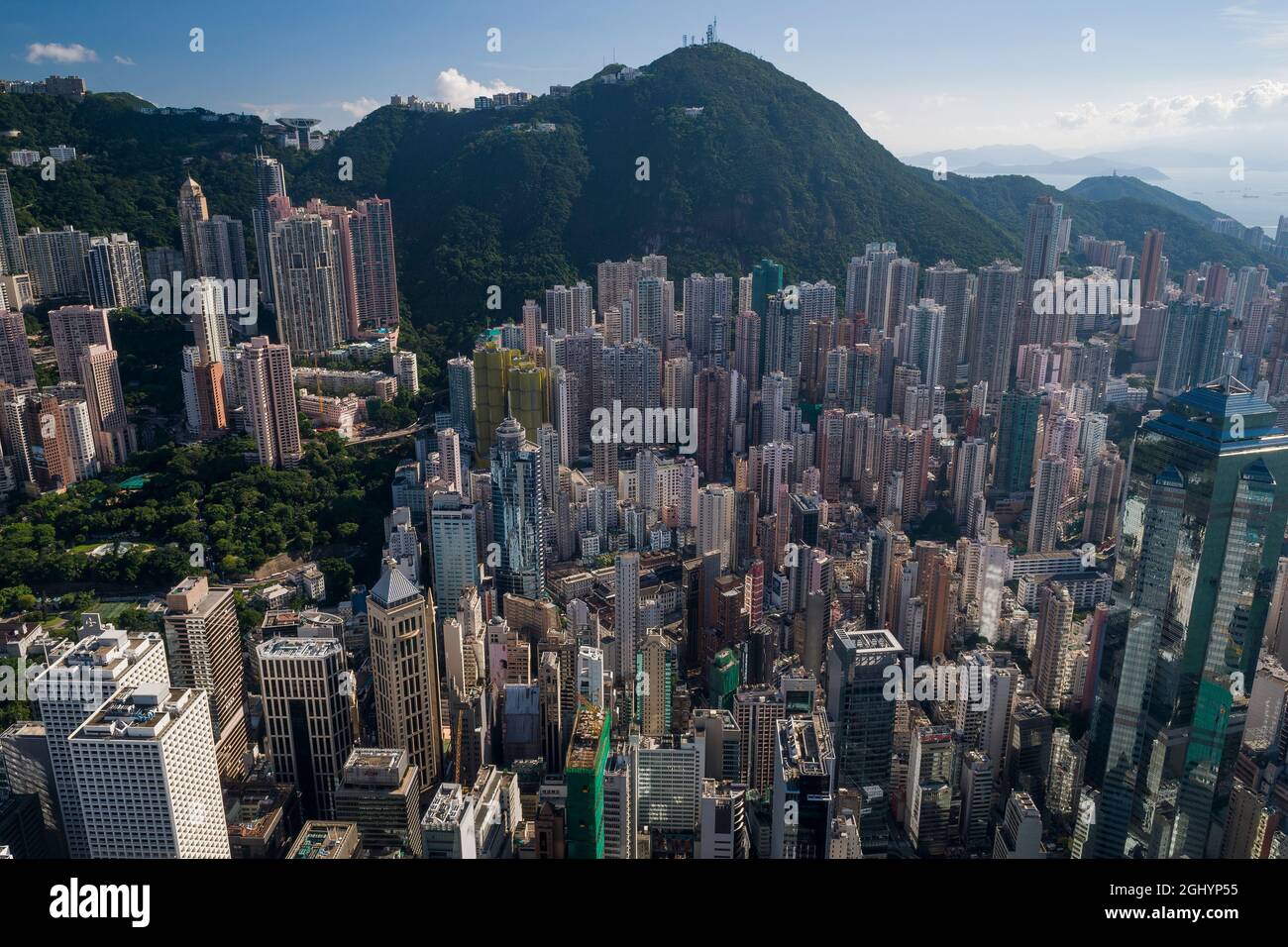 Gli alti blocchi di appartamenti residenziali di Mid-level e case di lusso sul Peak sopra gli edifici commerciali di Central, Hong Kong Island Foto Stock