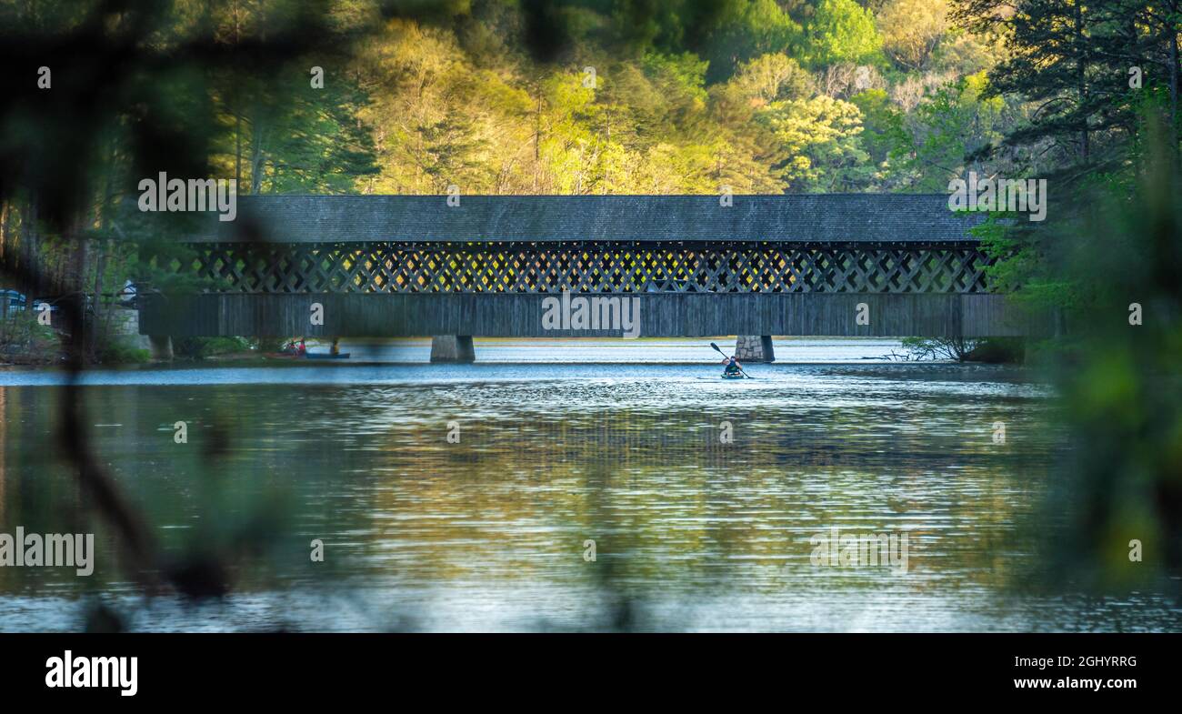 Kayak a pagaiare vicino al ponte coperto in una serata di primavera vicino al tramonto allo Stone Mountain Park di Atlanta, Georgia. (USA) Foto Stock