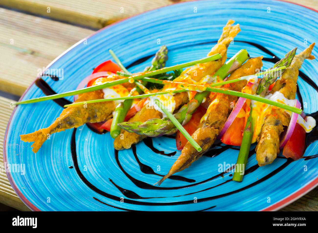 Acciughe in pastella con salsa e verdure Foto Stock