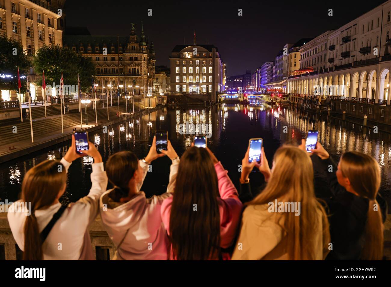 Amburgo, Germania. 07 settembre 2021. Le giovani donne fotografano il Municipio di Amburgo non illuminato. Amburgo partecipa alla "Notte della Terra" per attirare l'attenzione sul persistente inquinamento luminoso di notte. Nella notte della Terra, l'illuminazione degli edifici viene disattivata come segno visibile per una luce meno artificiale. Credit: Ulrich Perrey/dpa/Alamy Live News Foto Stock