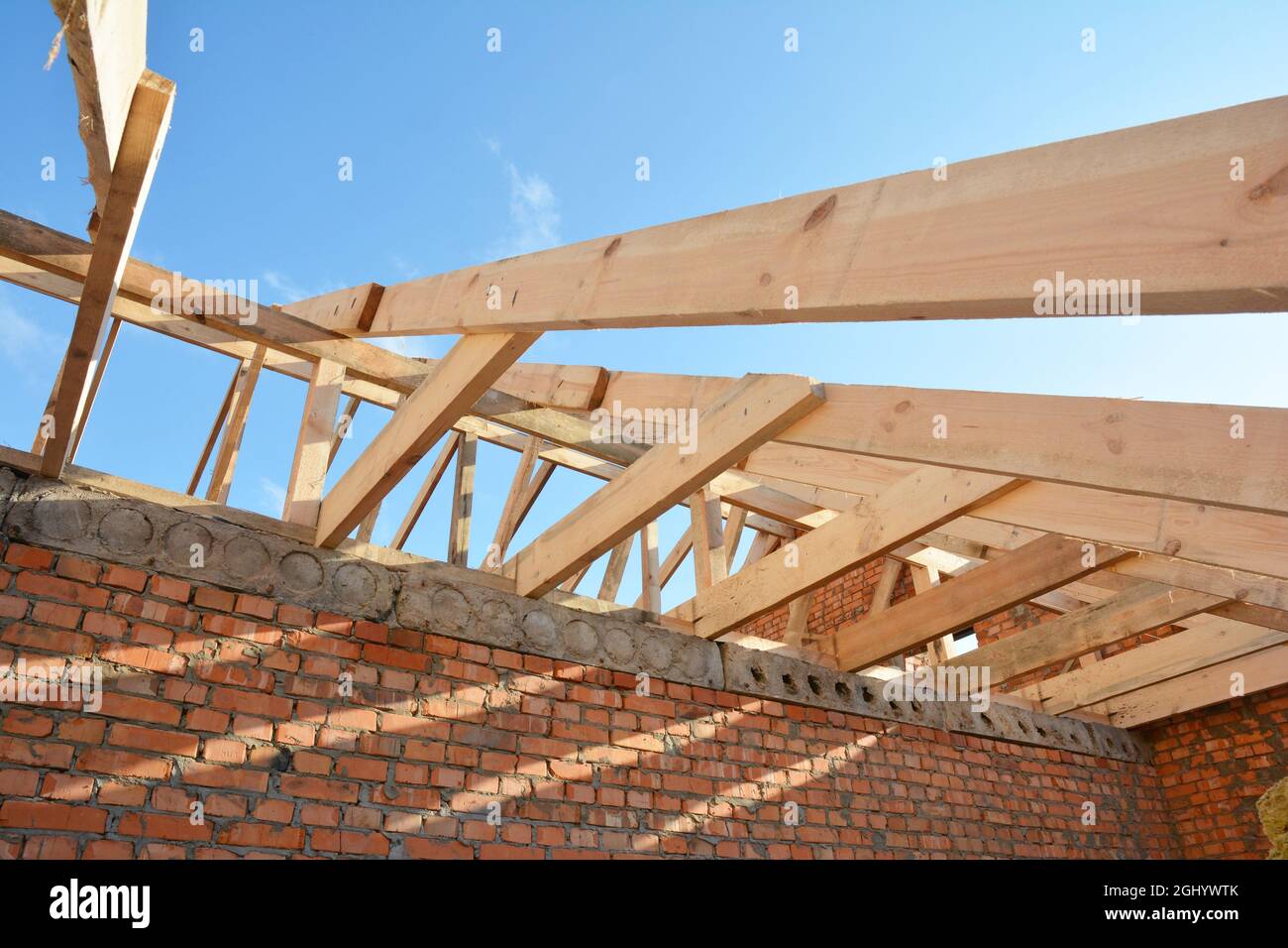 Costruzione di tetti sul palco di incorniciatura di tetto, installazione di  capriate in legno, gronde, bretelle e travi di tetto su una casa di mattoni  Foto stock - Alamy