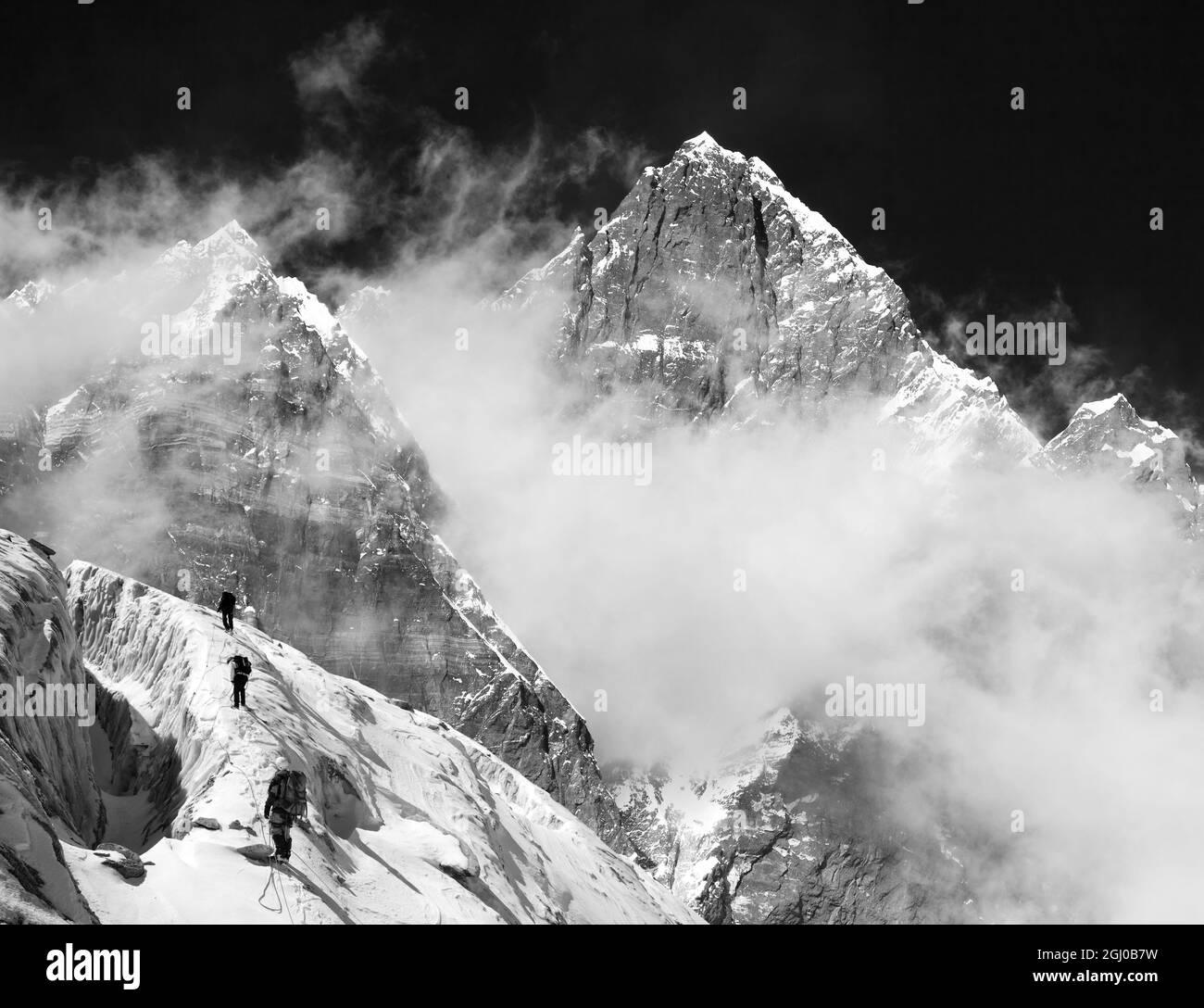 Monte Lhotse con le nuvole sulla cima - modo per il campo base Everest, valle di Khumbu, parco nazionale Sagarmatha, montagne nepalesi Himalaya, nero e. Foto Stock