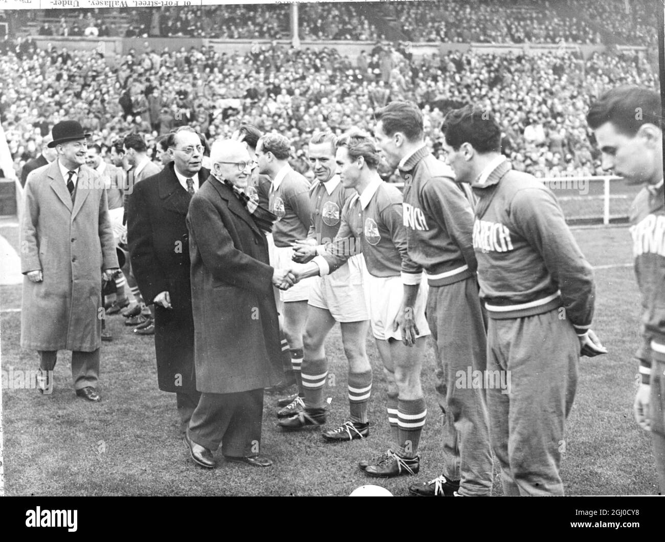 Jules Rimet, presidente della FIFA, ha sbattuto le mani con la squadra austriaca prima dell'inizio della partita contro l'Inghilterra l'11 novembre 1951 Foto Stock