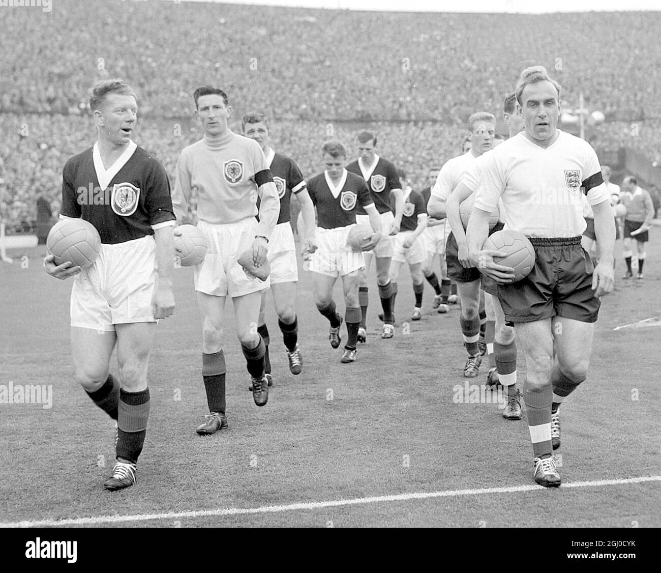 Inghilterra contro Scozia Gran Bretagna capitano Billy Wright guida la squadra inglese fuori nella sua 100esima partita per l'Inghilterra a Wembley. 11 Aprile 1959 Foto Stock