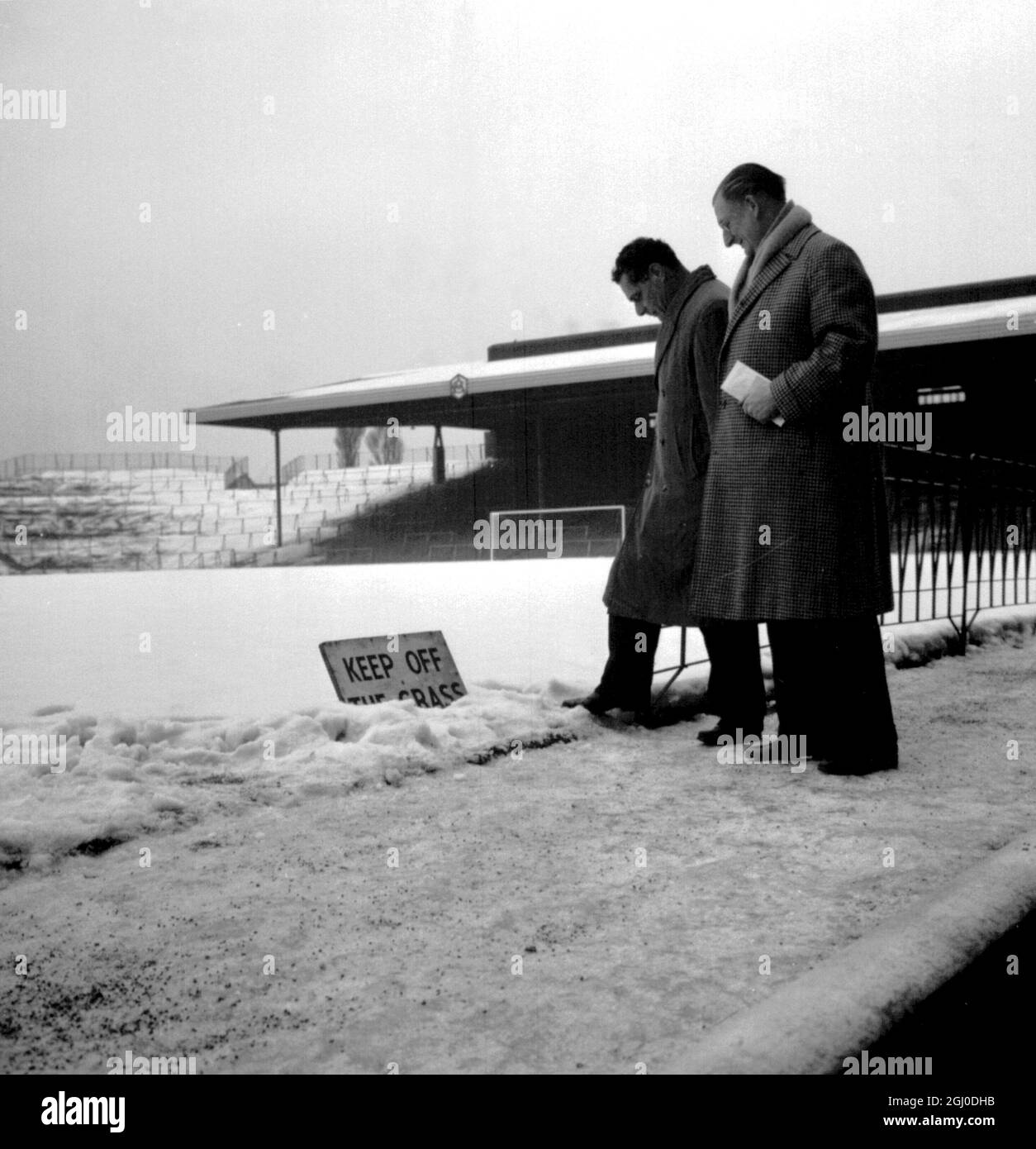 L'arbitro Jack Sturgeon (a sinistra) e il segretario del club Arsenal W.R. Wall (a destra) ispeziona il campo innevato all'Highbury Stadium di Londra prima di lanciare la terza partita di fa Cup tra l'Arsenal e l'Oxford United. 8 gennaio 1963. Foto Stock