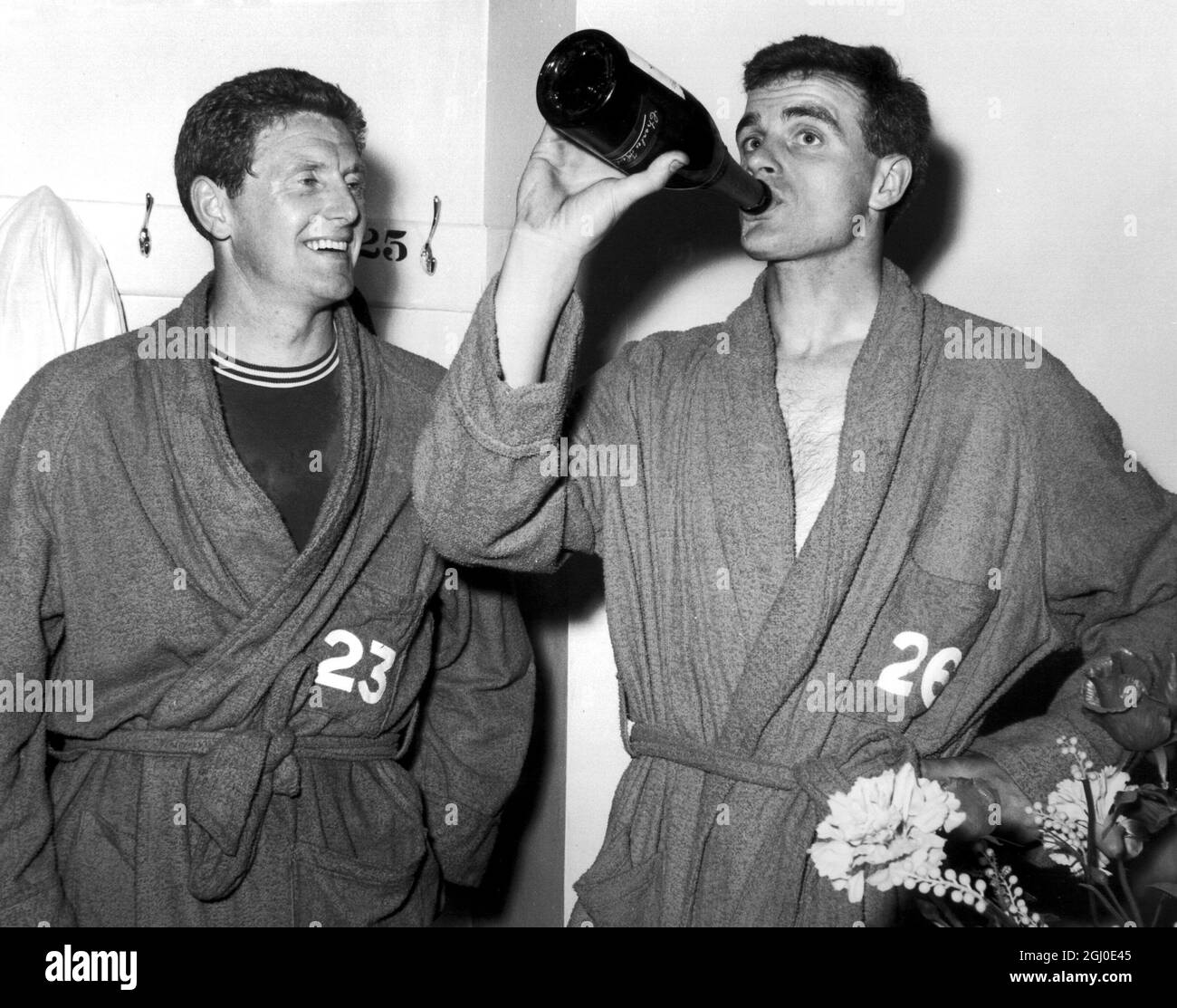 Chelsea Inside destra Derek Kevan, che ha segnato il primo gol del suo lato contro Portsmouth, guarda il compagno di squadra Frank Upton godendo di una celebrazione dello champagne nello spogliatoio per celebrare la promozione alla divisione uno. 22 maggio 1963. Foto Stock