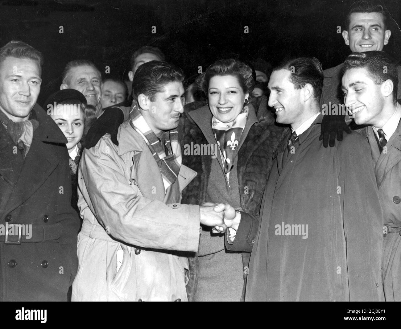 La squadra di calcio di Lille arrivò a Victoria e fu incontrata da Sylvie St.Clair, star francese del "quartiere Latino" - e membri della squadra di calcio di Chelsea, che incontrarono a Stamford Bridge. I due capitani Jan Baratte di Francia (a sinistra) scuote le mani con Harris il capitano Chelsea circondato da membri delle due squadre - con Sylvie St.Clair al centro - a Victoria. 14 novembre 1950 Foto Stock