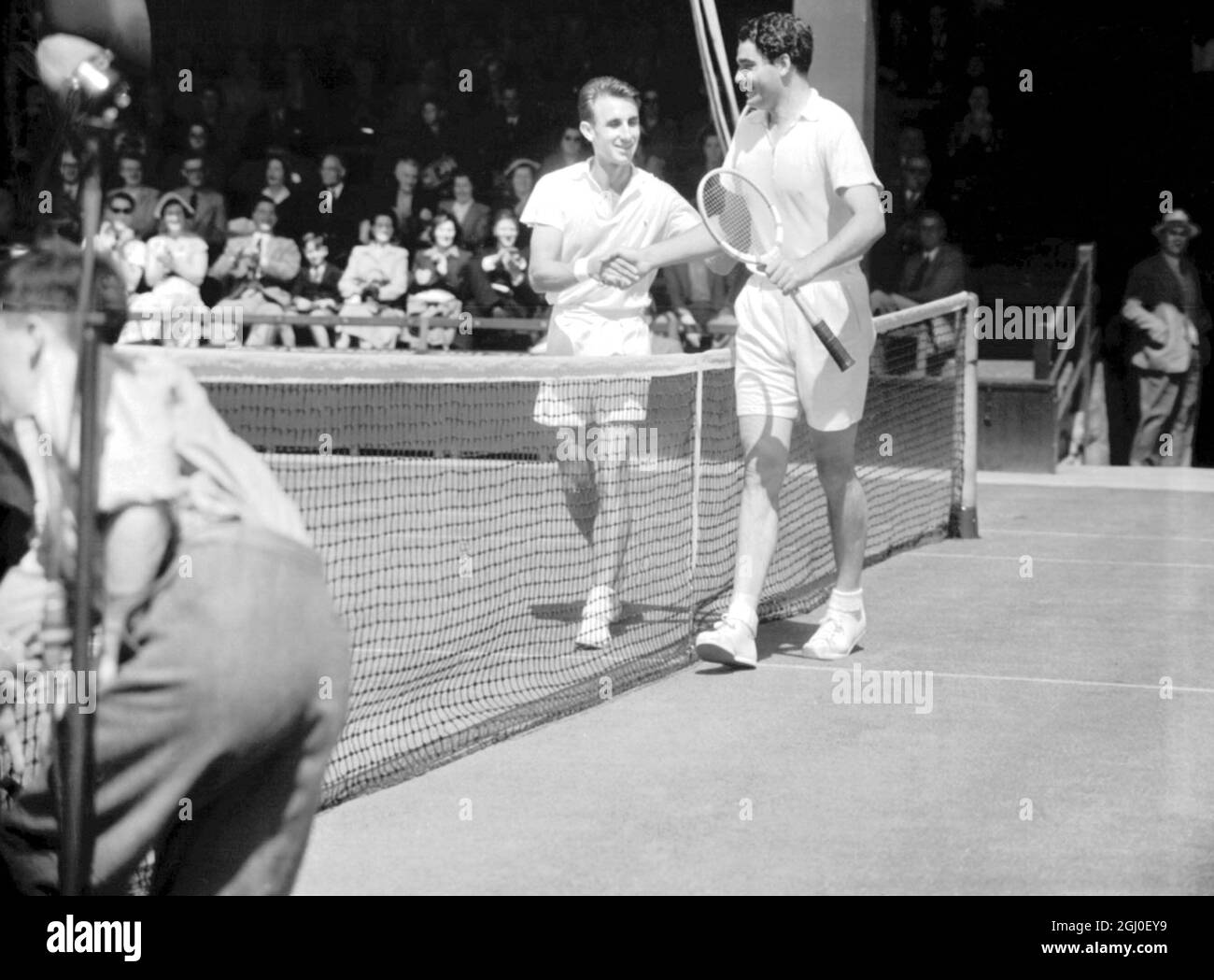 C.E. Wilderspin di Austrailia (a sinistra) e E. Buchholz, di Germania, scuotendo le mani dopo la loro corte una partita nella prima giornata del campionato di Wimbledon. L'australiano ha vinto 6-4 6-2 6-4. 22 giugno 1953 Foto Stock