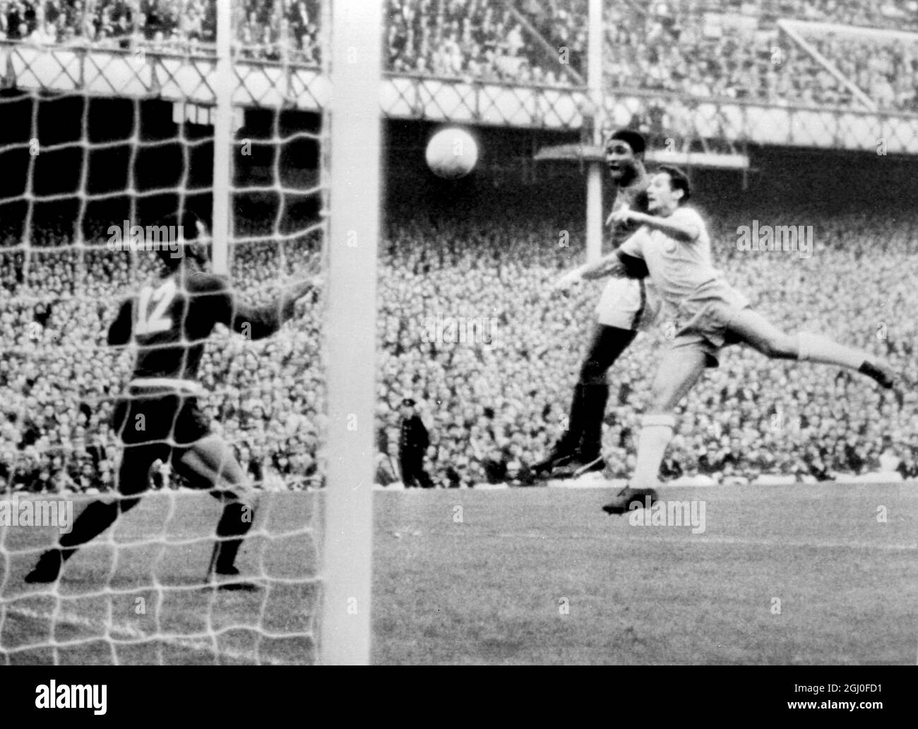1966 Coppa del mondo Portogallo / Brasile Eusebio segna il secondo gol del Portogallo con la testa durante la partita di Coppa del mondo contro il Brasile al Goodison Park. I giocatori brasiliani sono Orlando e il portiere Manga (No.12). 19 luglio 1966. Foto Stock