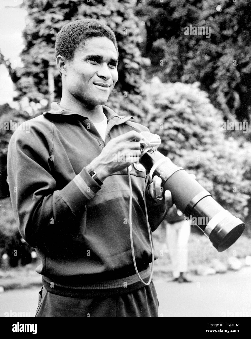 Eusebio del Portogallo prova la sua mano con una macchina da stampa durante una pausa di allenamento a Wilmslow, Cheshire prima dell'inizio delle finali della Coppa del mondo. 11 luglio 1966. Foto Stock