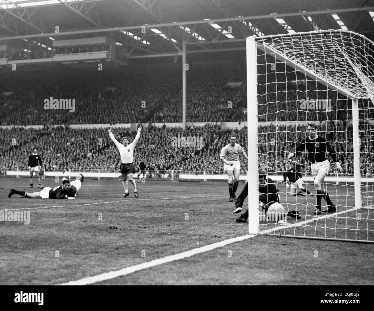 Inghilterra contro Scozia in una partita di qualificazione del Campionato europeo - Jackie Charlton (l) segna il primo gol dell'Inghilterra, in quanto Eddie McCreadie della Scozia non riesce a cancellare la propria posizione. 15 aprile 1967 Foto Stock