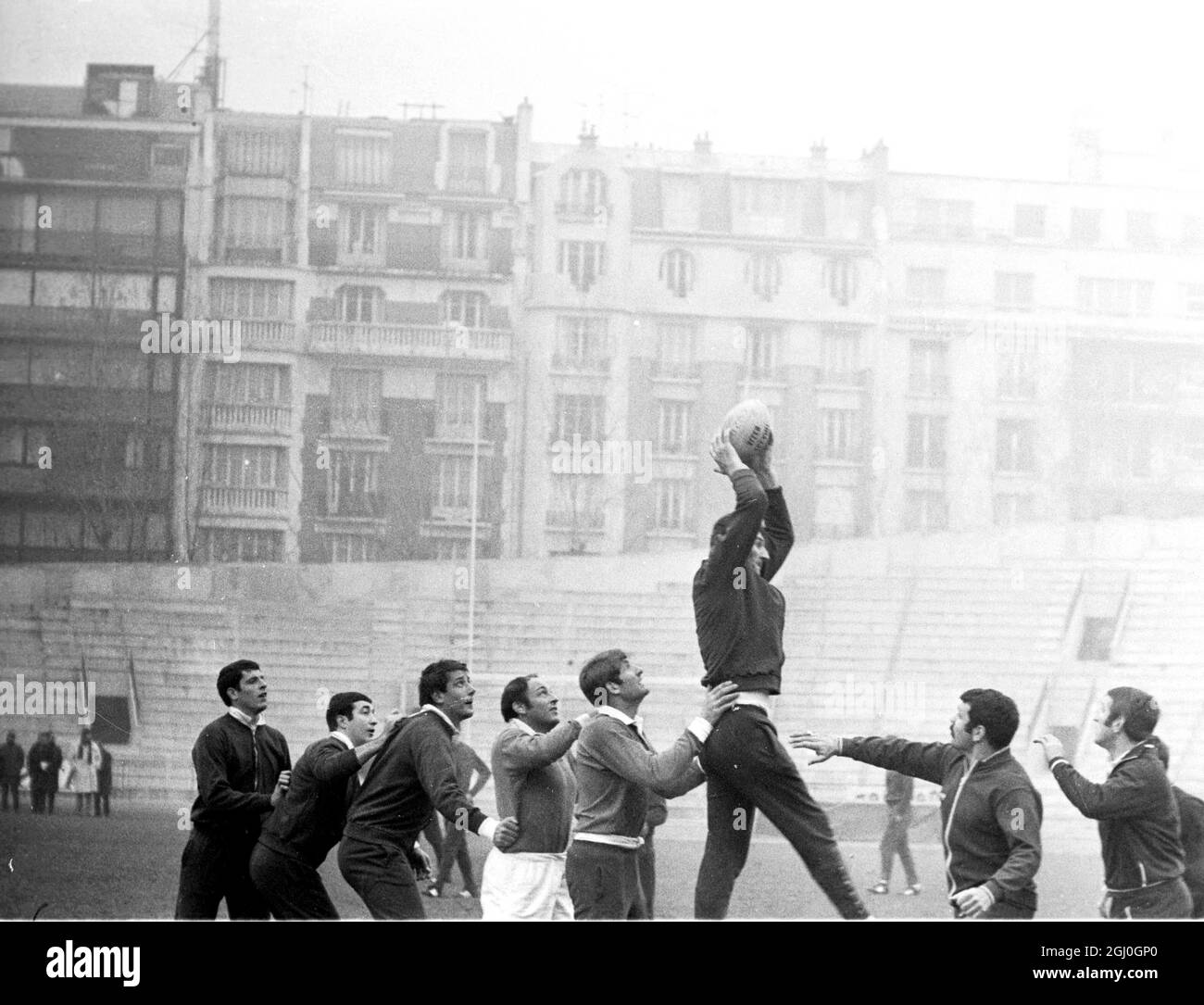 Benoit Dauga, membro della squadra di rugby francese, salta sopra i suoi colleghi per prendere la palla durante l'allenamento allo stadio Jean Bouin di Parigi, altri giocatori Aldo Gruarin, Walter Spanchero e Jacques Abadie 25 novembre 1967 Foto Stock